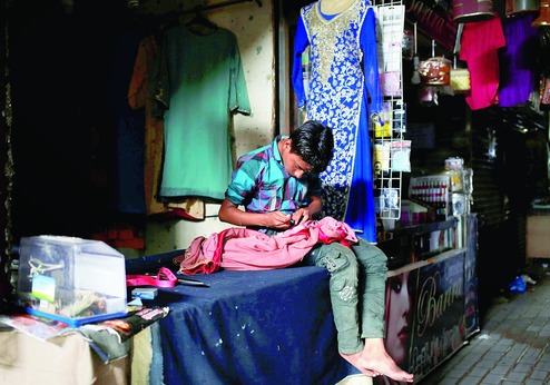 a boy outside a tailor shop during a power cut in karachi photo reuters