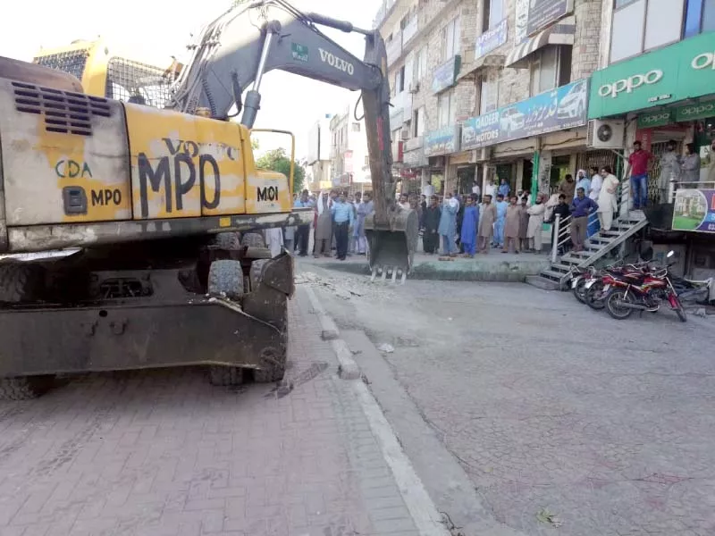 people watch as cda and icta officials demolish illegally constructed ramps outside a showroom in sector g 9 photo express people watch as cda and icta officials demolish illegally constructed ramps outside a showroom in sector g 9 photo express