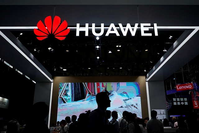 people walk past a huawei sign at ces consumer electronics show asia 2018 in shanghai china june 14 2018 photo reuters