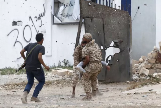 fighters loyal to libya 039 s government of national accord carry a wounded man as clashes rage south of the capital tripoli photo afp