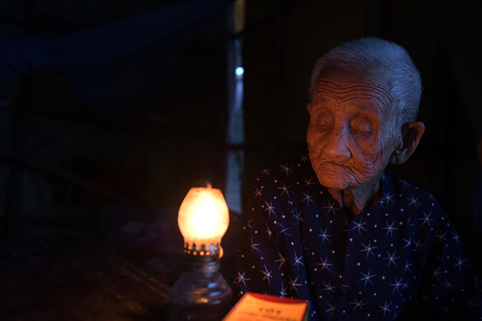 99 year old pham thi ca sitting beside an oil lamp in her makeshift shelter in van phong bay photo afp