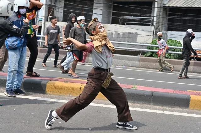 protesters hurl rocks toward police during a clash in jakarta on may 22 2019 photo afp protesters hurl rocks toward police during a clash in jakarta on may 22 2019 photo afp