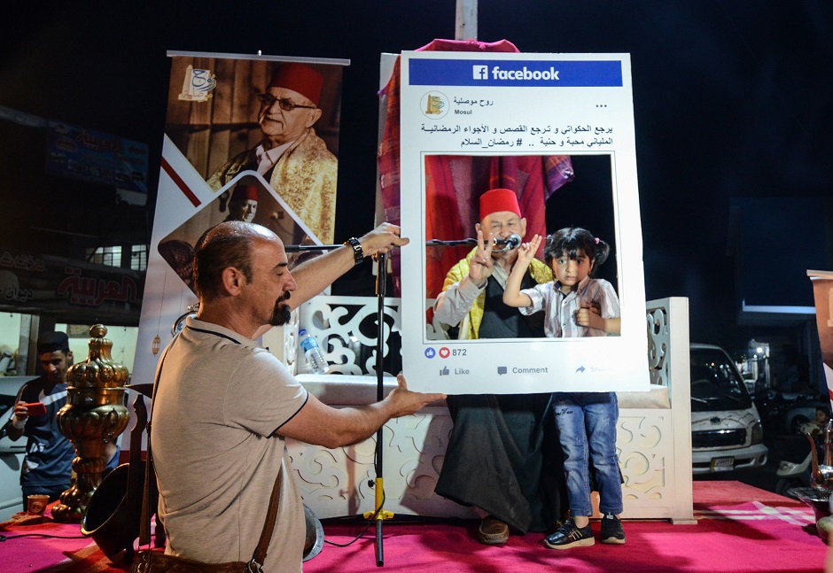 a young girl poses for a photograph with traditional storyteller abdel wahed ismail in the northern iraqi city of mosul photo afp