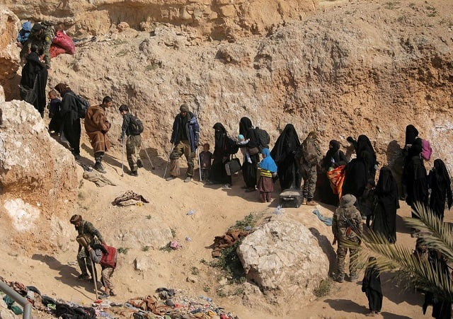 islamic state fighters and their families walk as they surrender in the village of baghouz deir al zor province syria march 12 2019 photo reuters islamic state fighters and their families walk as they surrender in the village of baghouz deir al zor province syria march 12 2019 photo reuters