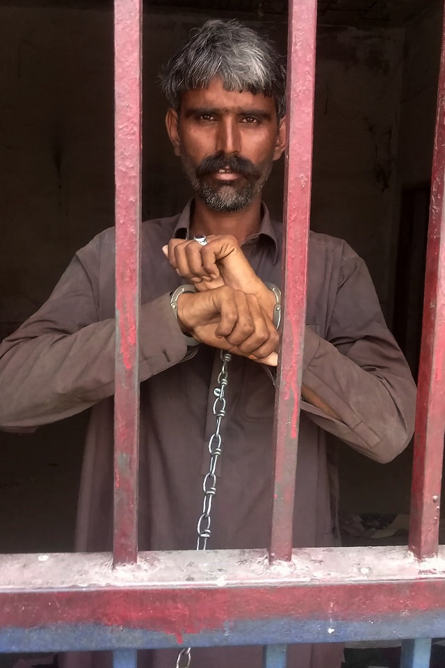 in this handout picture released by sindh police department on may 29 2019 a man who murder his hiv positive wife looks out from a police lockup in shikarpur district in pakistan 039 s southern sindh province   a pakistani man killed his hiv positive wife on may 29 in southern pakistan where hundreds of people have tested positive for the virus in recent weeks stirring panic and casting a light on the country s dismal public health standards photo afp