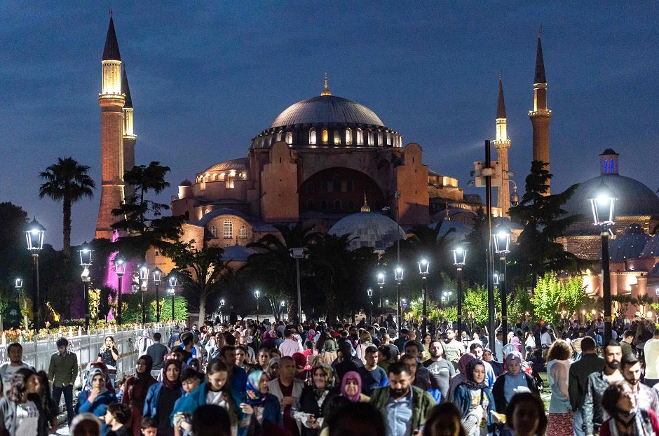 people stroll at the sunset in front of the blue mosque square in istanbul turkey photo afp