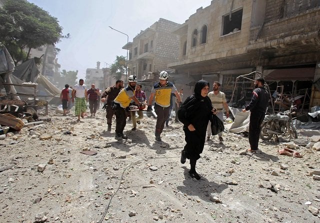 members of the syrian civil defence known as the white helmets carry a wounded man on a stretcher following a reported air strike on the town of maaret al numan in the jihadist held idlib province on june 3 2019 photo afp