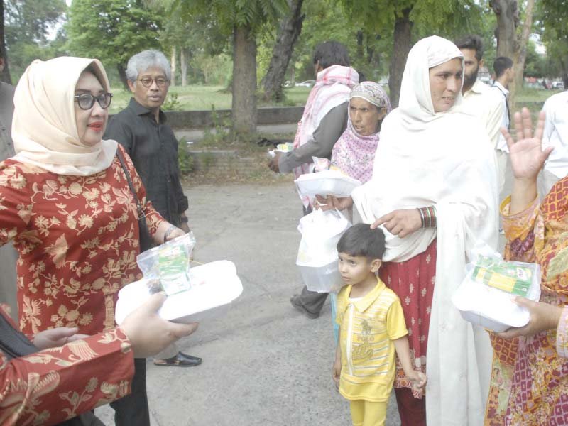 indonesian ambassador and his wife distributing food packages among needy people at aabpara photo online