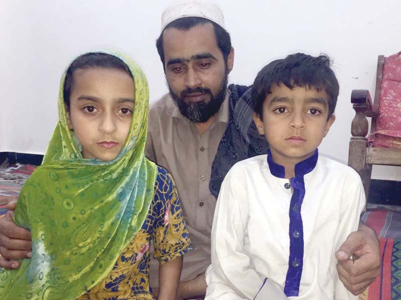 sadarat khan sits with his children mahnoor and sudais after their mother was killed by a train photo express