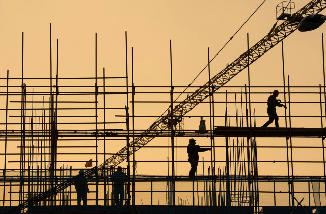 workers are seen on scaffolding at a construction site photo reuters workers are seen on scaffolding at a construction site photo reuters