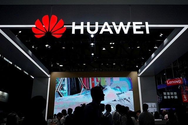 people walk past a huawei sign at ces consumer electronics show asia 2018 in shanghai china june 14 2018 photo reuters people walk past a huawei sign at ces consumer electronics show asia 2018 in shanghai china june 14 2018 photo reuters