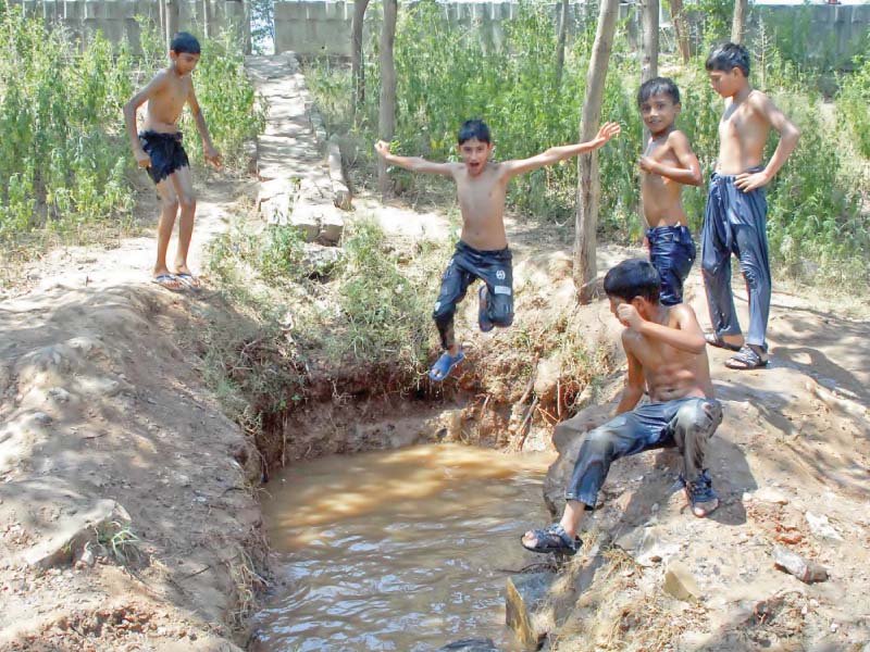 boys jump into a waterhole near zero point interchange in islamabad photo online