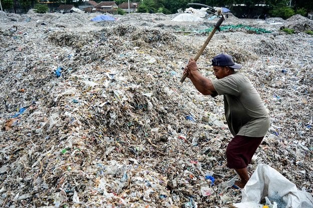 in this picture taken on december 11 2018 a man searches for plastic waste for resale at a dump in mojokerto east java province photo afp