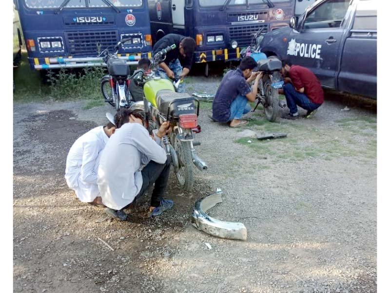 boys fit back the removed mudguards and other body parts of the bikes police had impounded for being used in one wheeling photo express