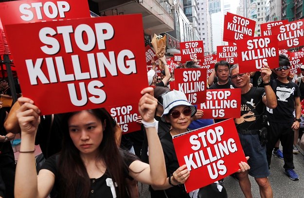 protesters hold placards as they attend a demonstration demanding hong kong 039 s leaders to step down and withdraw the extradition bill in hong kong photo reuters