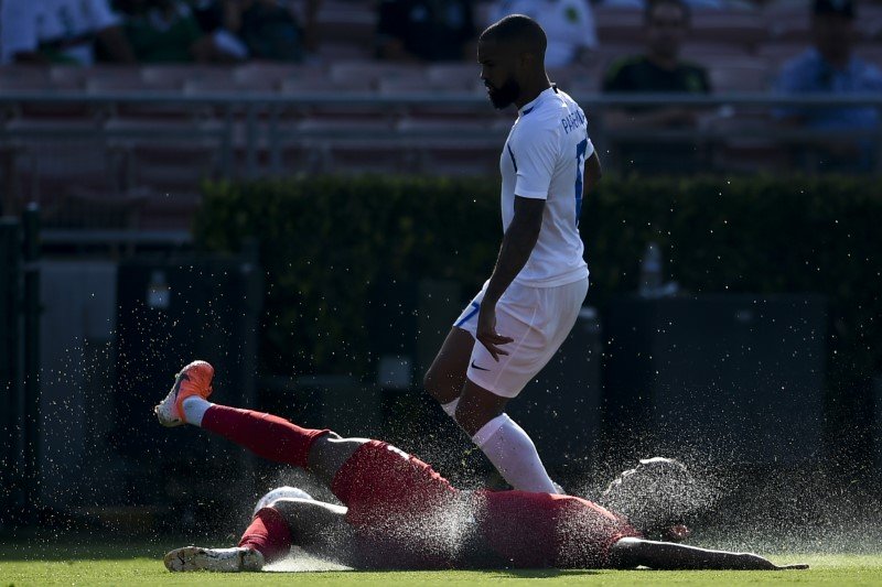 canada defender derek cornelius 4 slides for the ball in front of martinique forward kevin parsemain 17 during the second half of group play in the concacaf gold cup soccer tournament at rose bowl photo reuters