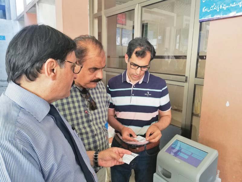 bbh officials check the newly installed token machine outside the testing laboratories of the hospital photo express