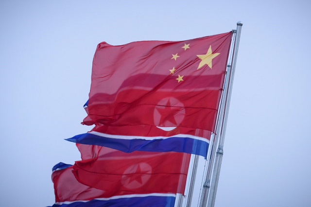 north korean and chinese flags fly on kim il sung square in pyongyang photo afp