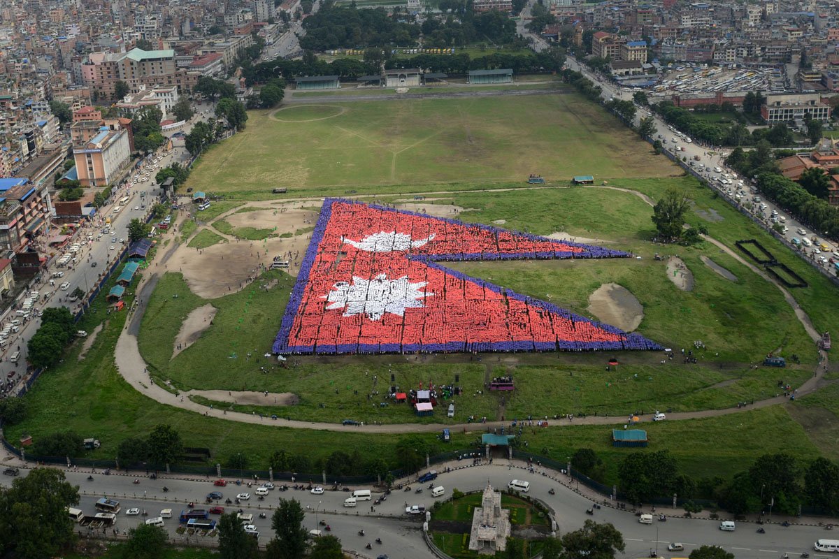 an aerial view of the nepalese national flag formed by over 35 000 people is seen at the tudikhel open ground in central kathmandu on august 23 2014 photo afp