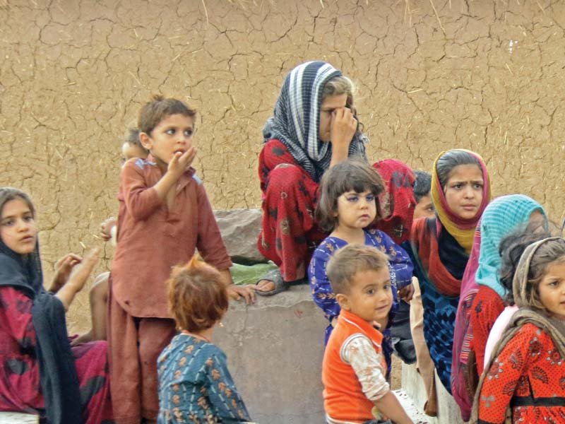 afghan children sit outside their mud house in a refugee camp in islamabad photo zafar aslam express