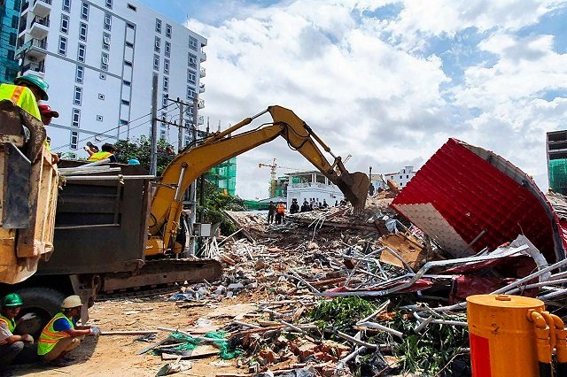 rescue workers use an earthmover to clear debris after an under construction building collapsed in sihanoukville photo afp