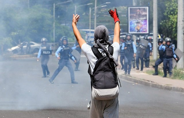 a student of the national autonomous university of honduras unah confronys riot police during a protest against the goverment of honduran president juan orlando hernandez in tegucigalpa on june 24 2019   ongoing protests against hernandez intensified last week after beginning more than a month ago when doctors and teachers unions held strikes against health and education laws photo afp