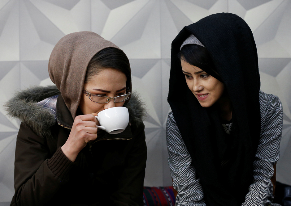 Sima Azimi (L), 20, a trainer and Sabera Bayanne, 20, a student at the Shaolin Wushu club, sit inside a restaurant. PHOTO: REUTERS