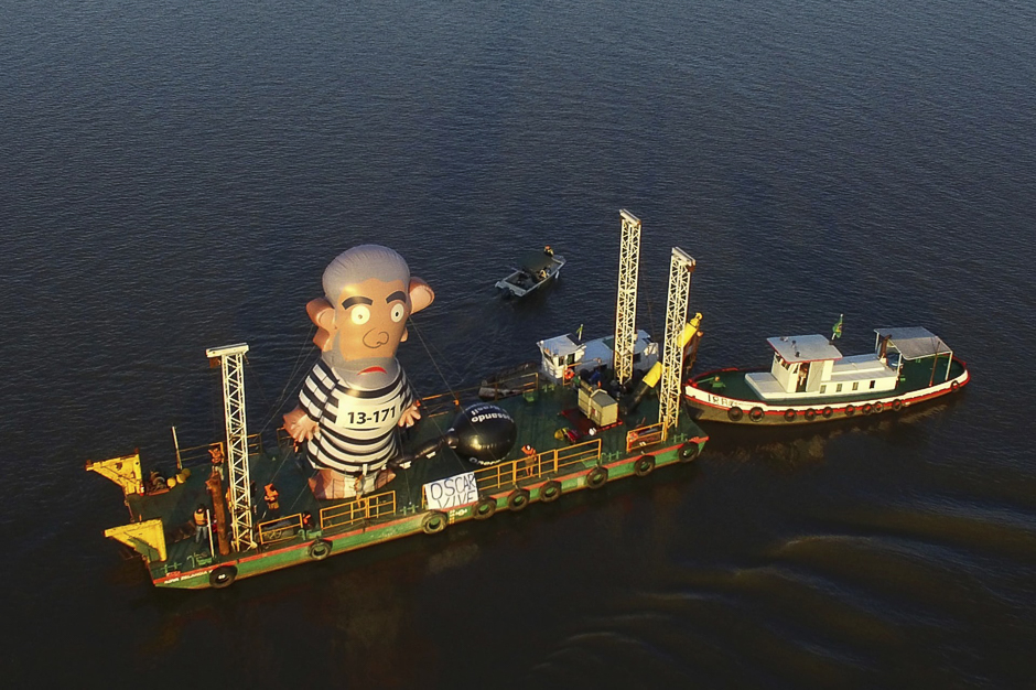 A large inflatable of former President Luiz Inacio Lula da Silva in prison garb is displayed on a boat on the river Guaiba, while an appellate court considers whether to uphold or throw out a corruption conviction against him, Porto Alegre, Brazil. PHOTO: AFP