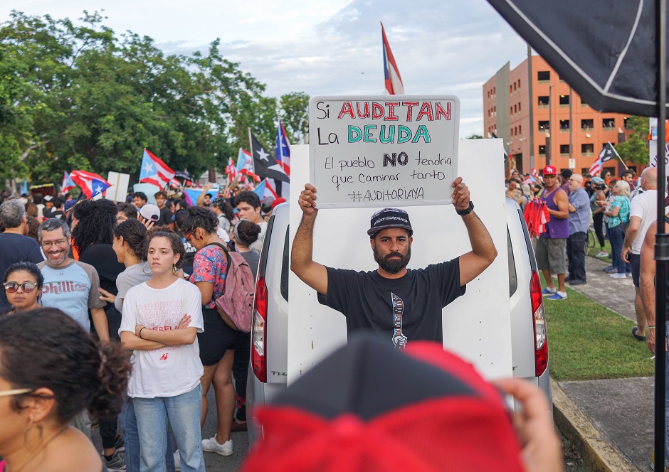 A protester is photographed in front of the Department of Justice during an anti-government demonstration in San Juan, Puerto Rico. PHOTO: AFP