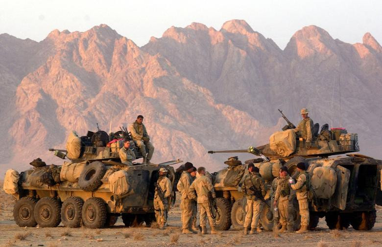 US Marines begin to form up their convoy at a staging area near Kandahar, as they await orders to begin their trek to Kandahar to take control of the airfield, December 13, 2001. [Photo: Reuters]