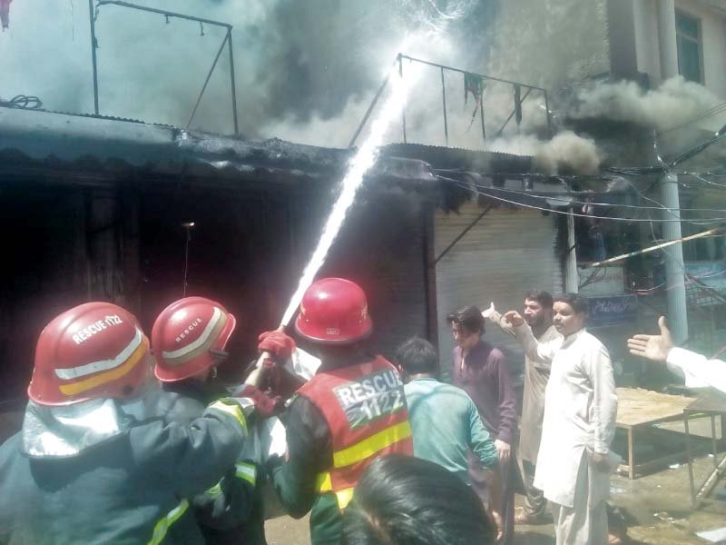 fire fighter trying to douse the fire which erupted in a market on chukri road photo express