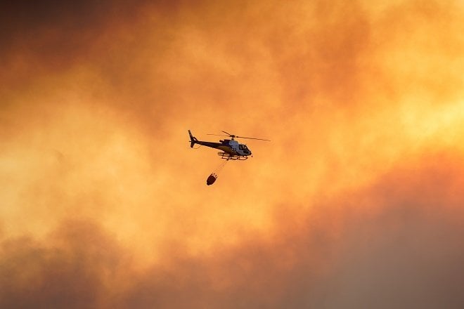 a helicopter flies over a wildfire near the city of toledo spain photo reuters