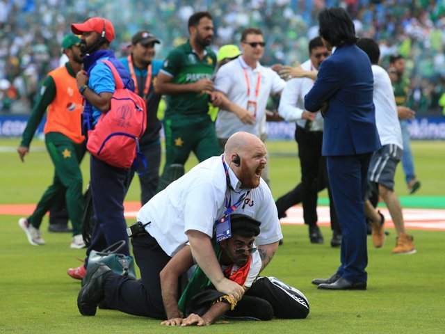 a security official stops a pitch invader after the 2019 cricket world cup group stage match between pakistan and afghanistan at headingley in leeds northern england on june 29 2019 photo afp