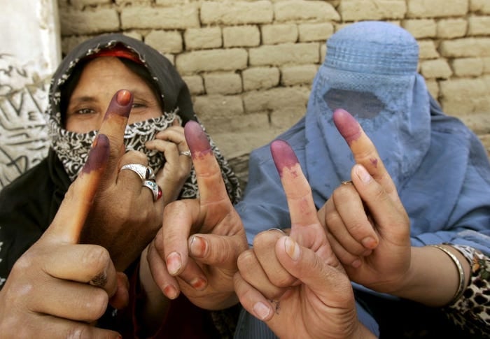 Afghan women show their inked fingers after they voted during parliamentary elections at a mosque used as a polling station in the Afghan capital Kabul, September 18, 2005. [Photo: Reuters]