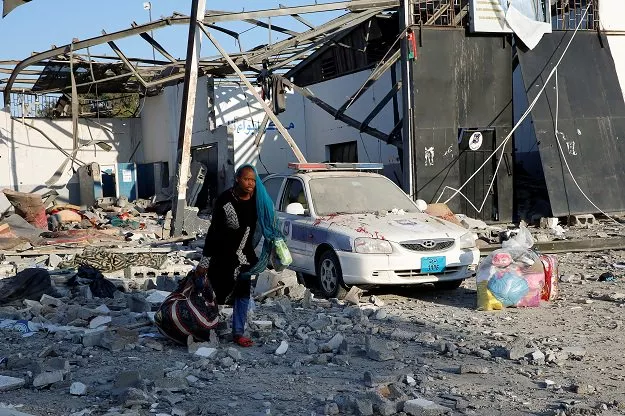 a migrant picks up her belongings from among rubble at a detention centre for mainly african migrants that was hit by an airstrike in the tajoura suburb of the libyan capital of tripoli photo reuters a migrant picks up her belongings from among rubble at a detention centre for mainly african migrants that was hit by an airstrike in the tajoura suburb of the libyan capital of tripoli photo reuters
