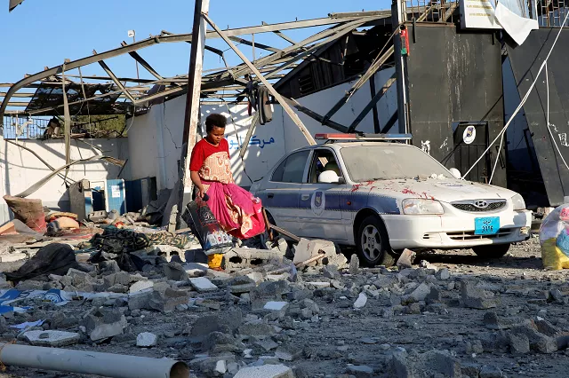 a migrant picks up clothes from among rubble of a detention centre for mainly african migrants hit by an air strike in the tajoura suburb of tripoli photo reuters a migrant picks up clothes from among rubble of a detention centre for mainly african migrants hit by an air strike in the tajoura suburb of tripoli photo reuters