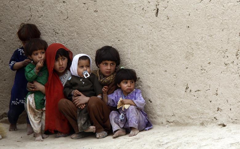 Afghan children look at Canadian soldiers of the NATO-led coalition while they patrol in their compound in the Taliban stronghold of Zhari district in Kandahar province, southern Afghanistan, March 19, 2009. [Photo: Reuters]