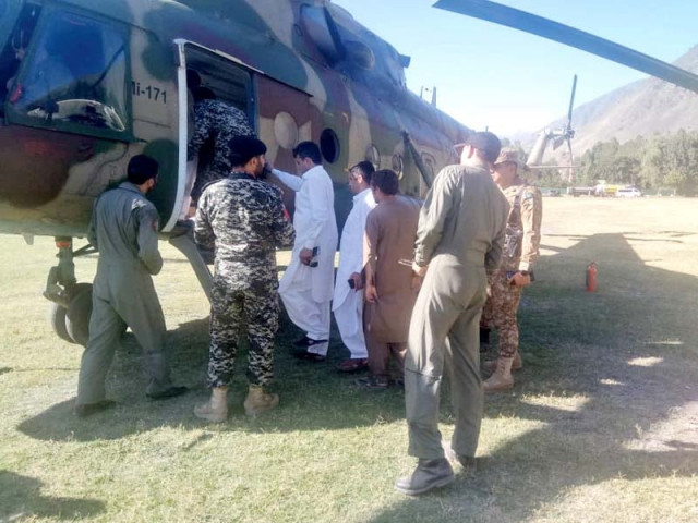 army personnel evacuate stranded people in a helicopter in chitral photo express army personnel evacuate stranded people in a helicopter in chitral photo express
