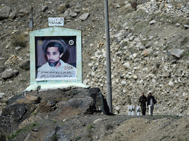 men walk next to a billboard with the image of ahmad shah massoud the late military and political afghan leader also known as the quot lion of panjshir quot in zaman kor in panjshir province north of the capital kabul photo reuters