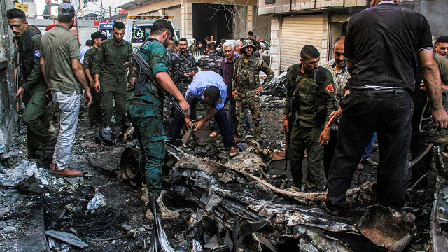 syrian kurdish security forces inspect the wreckage of a rigged car which detonated outside the syriac orthodox church of the virgin mary in the predominantly christian neighbourhood of al wasti in the kurdish majority city of qamishli in northeast syria on july 11 2019 photo afp
