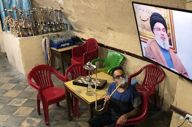 a man smokes a hookah as he watches lebanon 039 s hezbollah leader sayyed hassan nasrallah speak on television inside a coffee shop in the port city of sidon lebanon july 12 2019 photo reuters