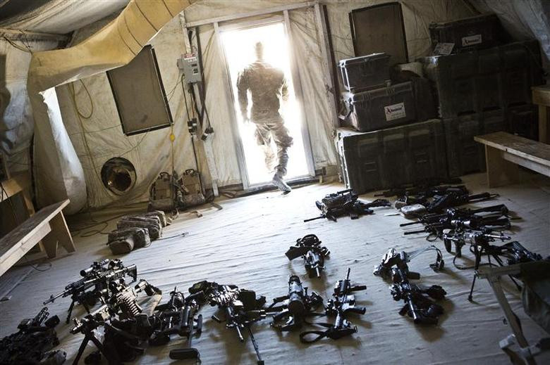 A soldier from 1st Platoon, Alpha Company, 1st Battalion, 36th Infantry leaves a room while checking the inventory of weapons at Strong Point DeMaiwand, Maywand District, Kandahar Province, Afghanistan, January 20, 2013. [Photo: Reuters]
