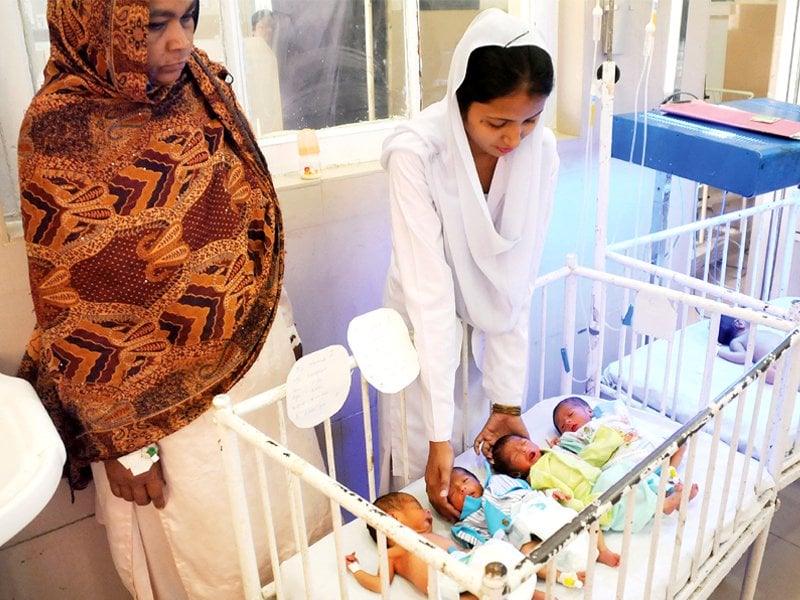 a nurse tends to the newborns as their mother looks on photo waseem imran express