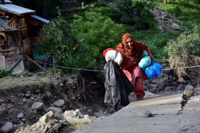 picture flood affected victims walk past a damaged road in laswa valley ajk photo afp picture flood affected victims walk past a damaged road in laswa valley ajk photo afp