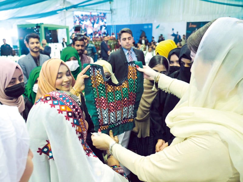 students present a traditional balochi dress to punjab chief minister during the honhaar scholarship ceremony at ghazi university photo express