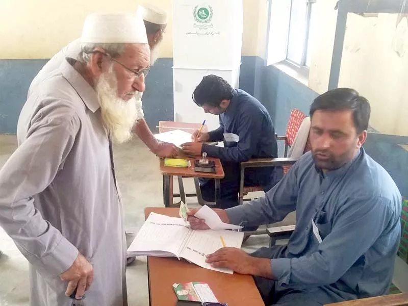peshawar corps commander lt gen shaheen mazhar mehmood visits a polling station people come marching with national flags to cast their votes and a polling official checks the cnic of an elderly man at a polling booth during elections in the merged districts photos express peshawar corps commander lt gen shaheen mazhar mehmood visits a polling station people come marching with national flags to cast their votes and a polling official checks the cnic of an elderly man at a polling booth during elections in the merged districts photos express