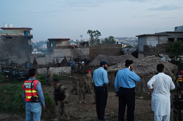 security officials gather at the scene where a pakistani army aviation corps aircraft crashed in rawalpindi photo afp