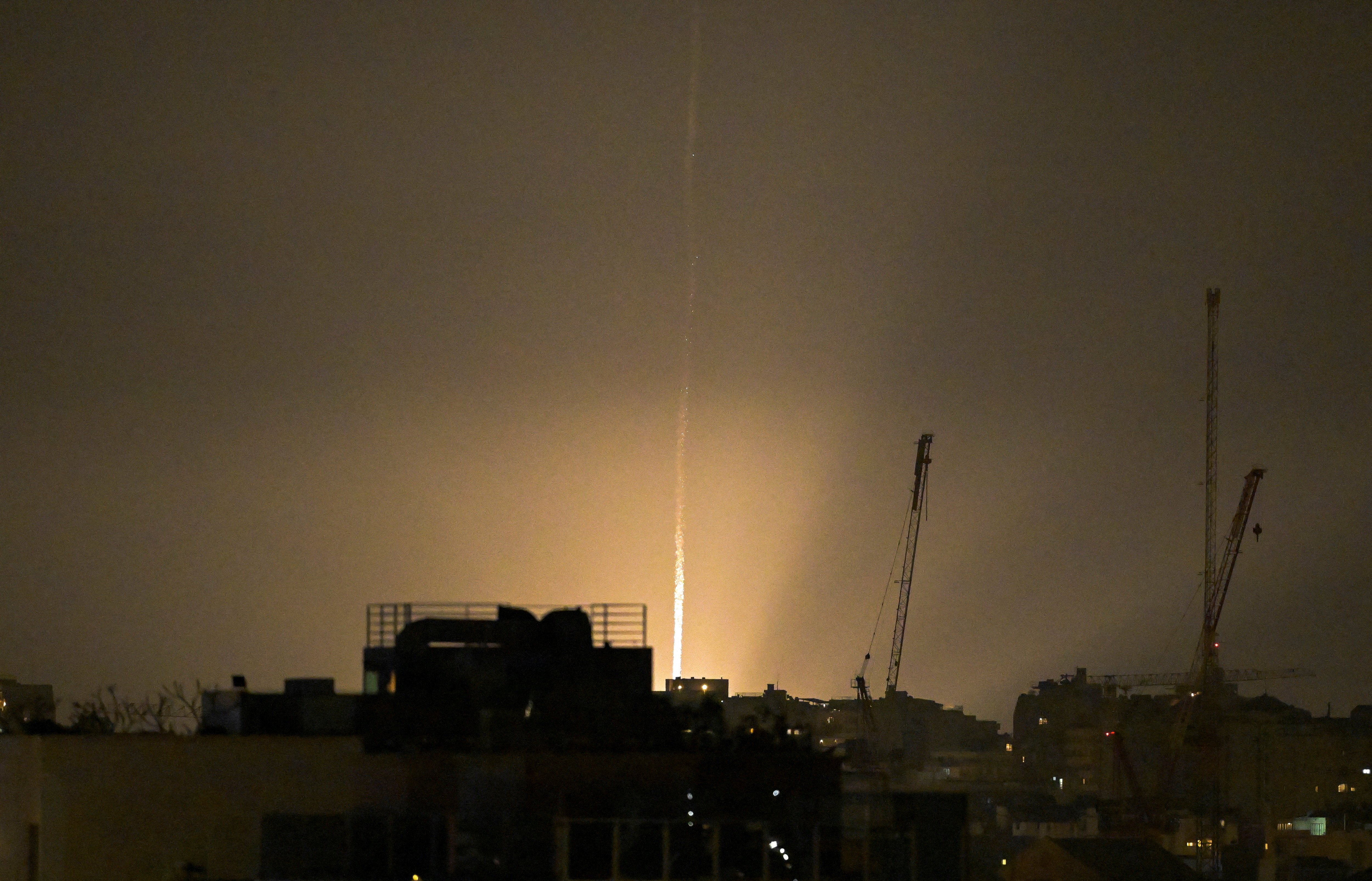 The sky is illuminated as an Iranian missile lands in Israel, amid the U.S.-Israeli conflict with Iran, as seen from Tel Aviv, Israel, March 12, 2026. PHOTO: REUTERS
