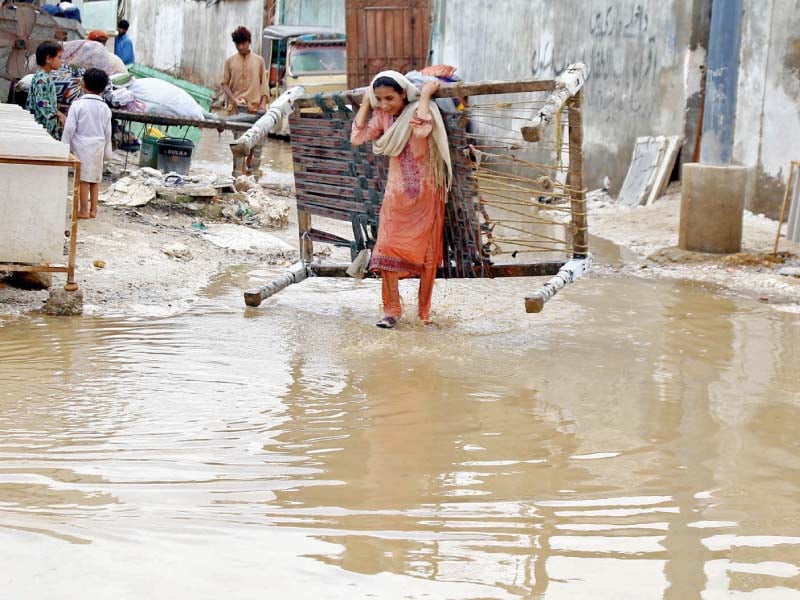 a woman retrieves her belongings from her house that has been flooded by rain water in a low lying area of the city the first spell of monsoon rain wreaked havoc in the city as the storm water drains were choked and did not allow water to pass through photos inp