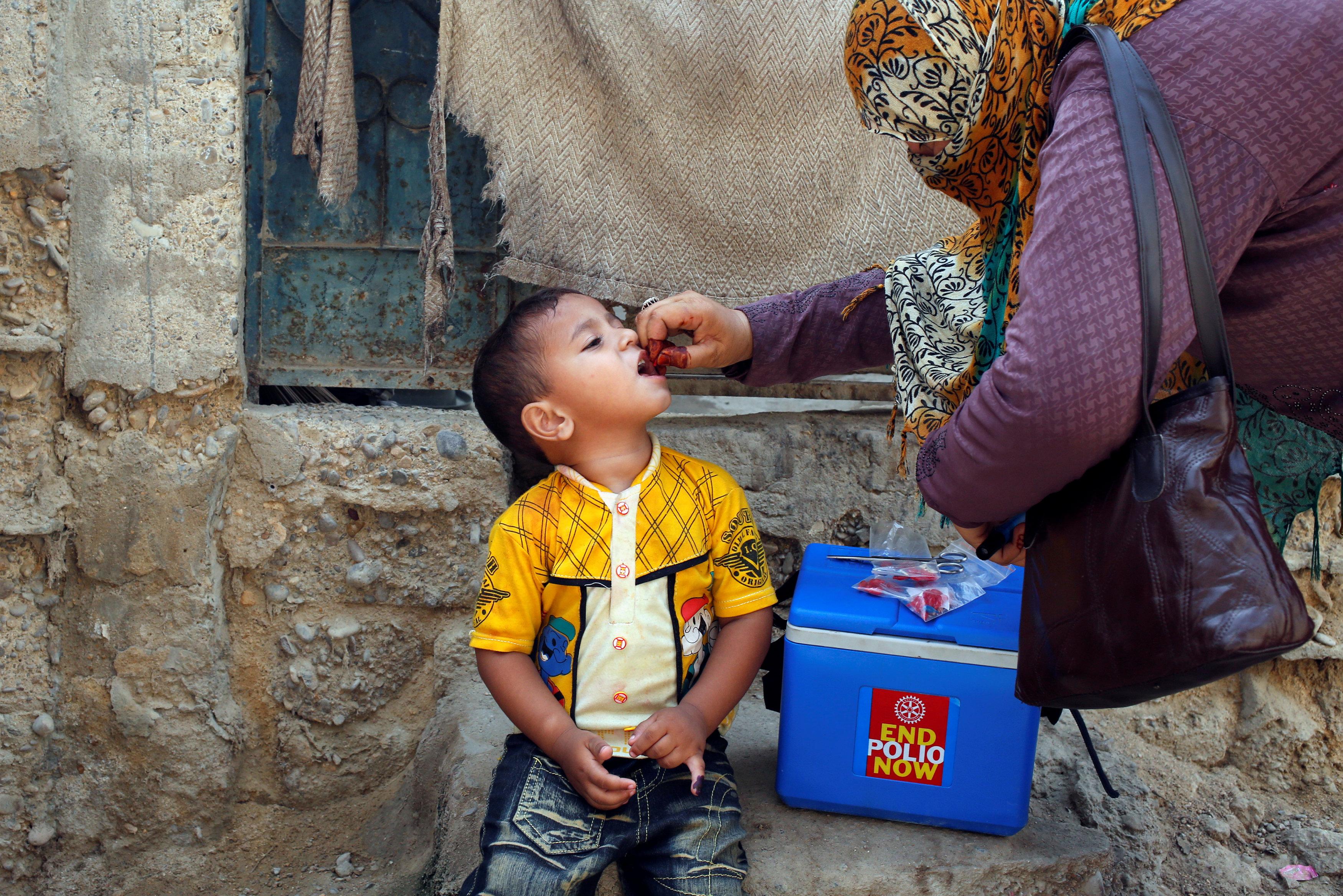 a polio worker is administering drops to a child photo reuters